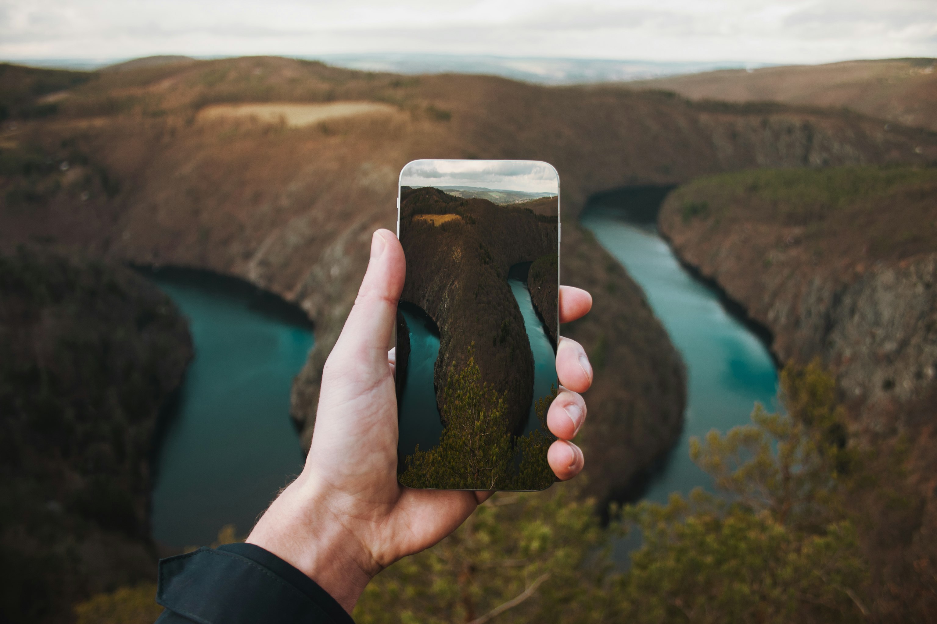 person taking a picture to the cliff